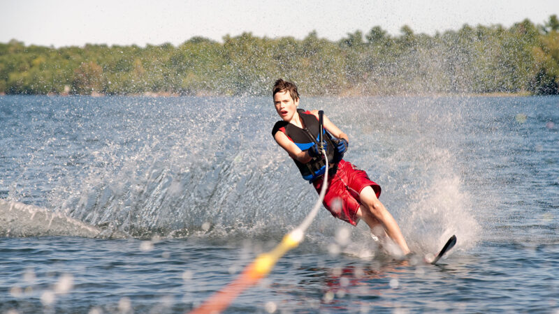 Teenage boy waterskiing on a lake