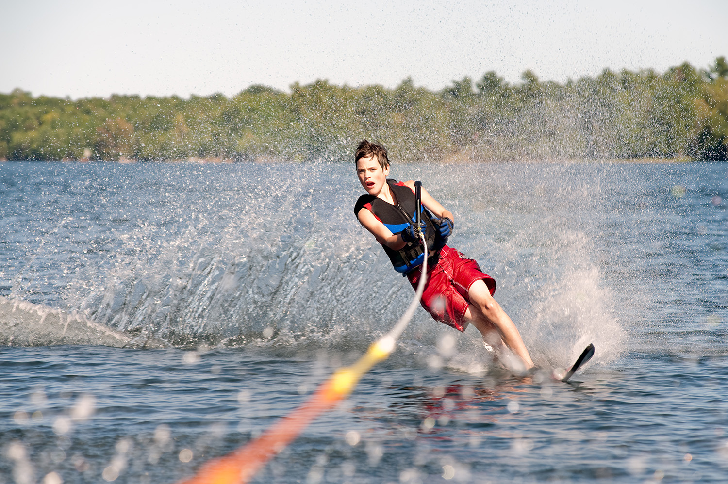 Teenage boy waterskiing on a lake